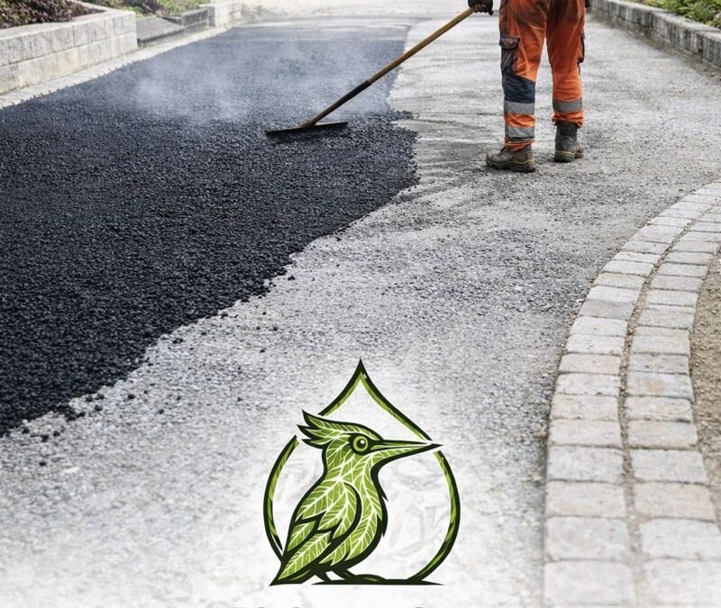 Ouvrier réalisant la pose d’un enrobé à chaud pour une cour extérieure avec bordures en pavés et fondation en grave ciment, logo Woodpecker Paysagiste en bas d’image